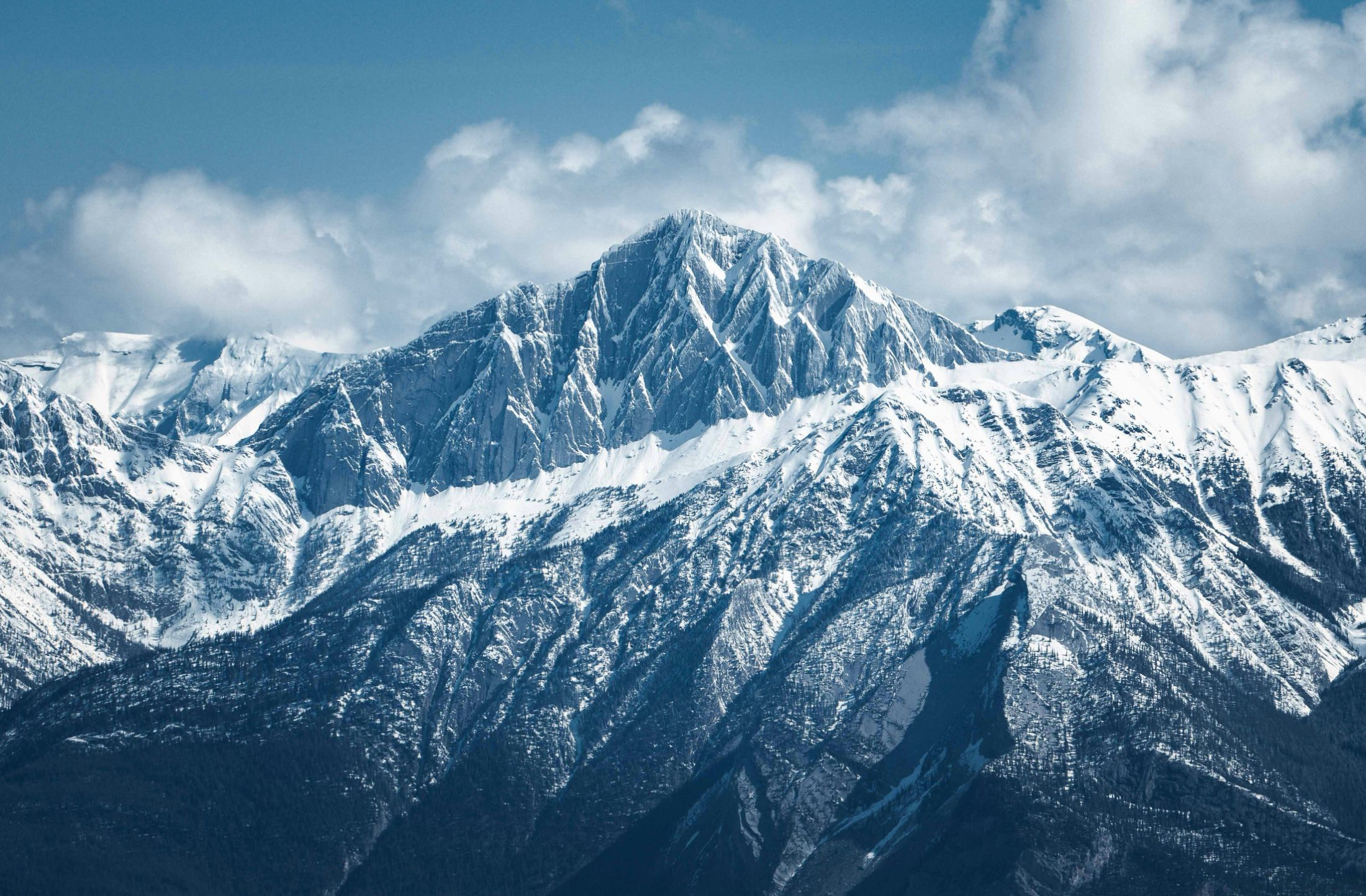 Una cumbre piramidal envuelta en nubes domina el valle